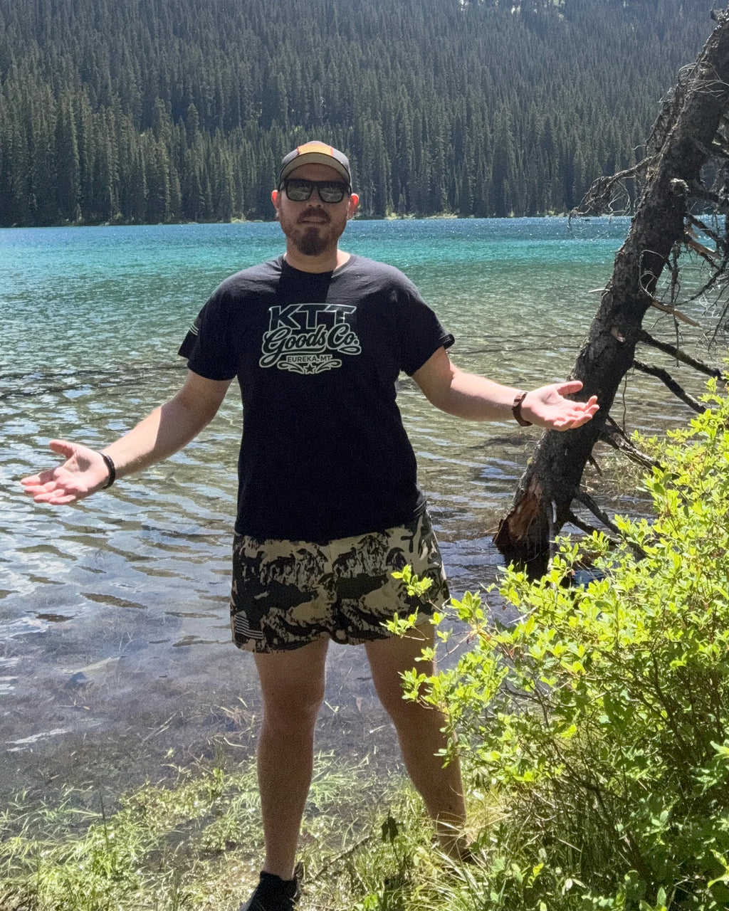 Cody wearing KTT TV-D1 athletic shorts beside a mountain lake in northwest Montana